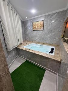 een jacuzzi in een kamer met een groene vloer bij Pousada Beira Rio in Santo Antônio do Pinhal