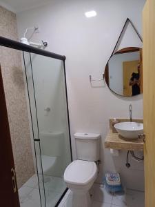 a bathroom with a toilet and a sink and a mirror at Casinha top perto Águas Quentes in Barra do Garças +8 photos