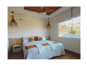 a bedroom with a bed with towels on it at Palmares, Casa de praia in Búzios +43 photos