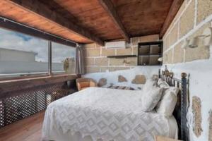 a bedroom with a bed and a large window at F tamaide in San Miguel de Abona