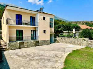 a building with blue windows and a stone wall at Mountin View Villa & Rafting In Permet in Përmet
