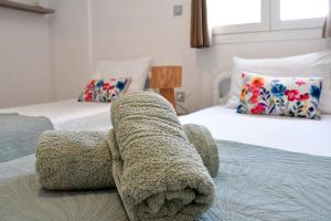 a bedroom with two beds with towels on the bed at Mitsakos Golden Villa in Egina