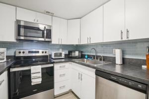 a kitchen with white cabinets and stainless steel appliances at The Trails M262 I Spacious 2 Bed 2 Bath in Gainesville