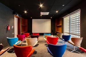 een kamer met kleurrijke stoelen voor een scherm bij Condôminio Latitude 23 - Ubatuba in Ubatuba