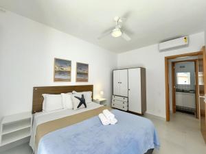 een slaapkamer met een bed met twee witte handdoeken erop bij Condôminio Latitude 23 - Ubatuba in Ubatuba +32 foto's