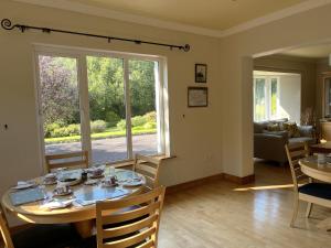 una sala da pranzo con tavolo e un soggiorno di PK Lodge Bed and breakfast a Skibbereen