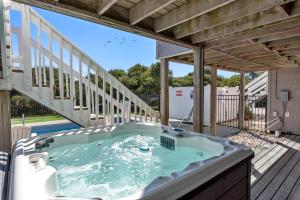 a jacuzzi tub on a deck with stairs at Serenity Shores in Southern Shores