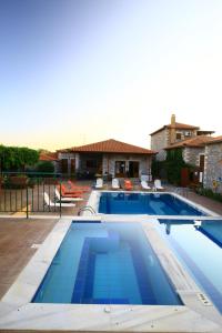 a large swimming pool with blue water in front of a house at Stephanou Inn in Agios Nikolaos