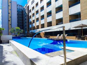 a swimming pool in front of a building at Aptos super confortáveis no Gold Flat by Apartamentos Jampa in João Pessoa