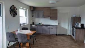a kitchen with a table and chairs in a room at Ferienwohnung Alpy in Schlaiten