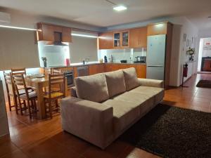 a living room with a couch and a kitchen at Casa do Diniz in Travassos