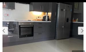 a kitchen with stainless steel appliances and a refrigerator at Belfast Mac -Double Room shared bathroom in Belfast