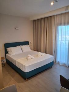 Un dormitorio con una cama con toallas. en Theasis Deluxe, en Lefkada