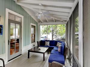 a screened in porch with a blue couch and a table at Sand Piper in Seacrest