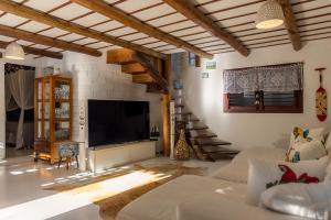 un soggiorno con divano e TV a schermo piatto di Casa Serendipity Trancoso a Porto Seguro