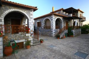 a stone house with a balcony and a patio at Stephanou Inn in Agios Nikolaos +30 photos