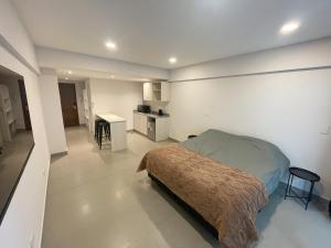 a bedroom with a bed and a kitchen in it at Otero Coliving - Studio Entero U6 in San Salvador de Jujuy