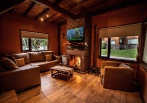 a living room with a couch and a fireplace at Guardianes Del Bayo in Villa La Angostura