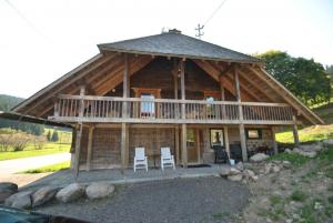 eine große Blockhütte mit Stühlen und einer Veranda in der Unterkunft Romantisches Schwarzwaldhaus in Äule