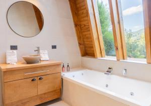 a bathroom with a tub and a sink and a mirror at Guardianes Del Bayo in Villa La Angostura