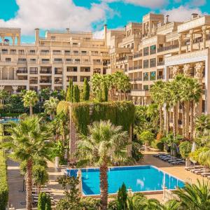 Una imagen de un gran edificio con palmeras y una piscina. en ARGISHT apart 647, en Golden Sands