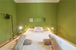 ein grünes Schlafzimmer mit einem großen Bett mit zwei Paar Socken in der Unterkunft Chez papy Charles in Carcassonne