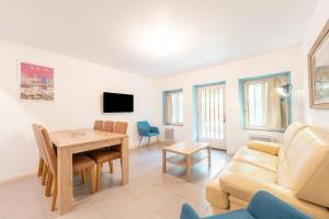 ein Wohnzimmer mit einem Tisch und einem Sofa in der Unterkunft Chez papy Charles in Carcassonne