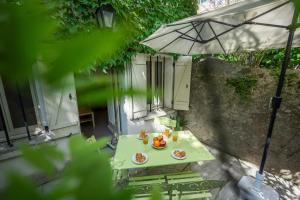 einen Tisch mit Essen und einen Regenschirm auf einer Terrasse in der Unterkunft Chez papy Charles in Carcassonne + 20 Fotos