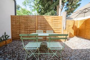 eine Terrasse mit Tisch und Stühlen und einem Zaun in der Unterkunft Chez papy Charles in Carcassonne