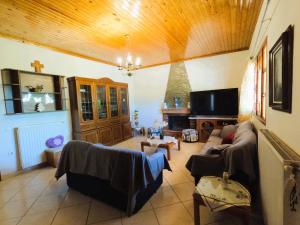 a living room with a couch and a tv at Meraki House Kalamaki in Kalamáki