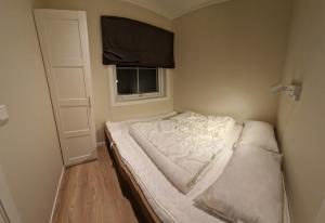 Posto letto in una piccola camera con finestra di Newly renovated apartment Gautefall a Drangedal
