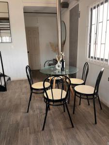 a glass table and chairs in a room at Casa en Pichilemu acogedora y amplia Casa Lile in Pichilemu +10 photos