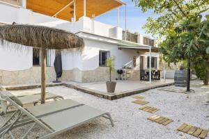 a patio with chairs and an umbrella and a house at Casa Pitaya in Alhaurín el Grande