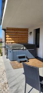 eine Terrasse mit Grill und einem Tisch und zwei Stühlen in der Unterkunft Domki z jacuzzi Zacisze w Górach in Sosnowka