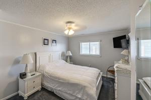une chambre avec un lit blanc et une télévision dans l'établissement Family-Friendly Ocean City Condo Walk to Beach!, à Ocean City