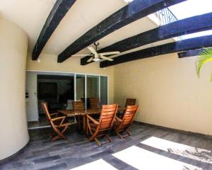 una sala da pranzo con tavolo, sedie e ventilatore a soffitto di Villa con Alberca Princess ad Acapulco