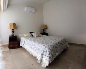 una camera da letto con un letto con due lampade sopra di Villa con Alberca Princess ad Acapulco Altre 5 foto