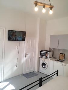 a kitchen with a microwave and a washing machine at Thalassa Blu Mykonos Apartament in Mýkonos City