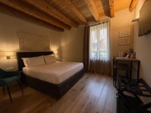 a bedroom with a large bed and a window at Malvezzi24 Boutique Rooms in Desenzano del Garda