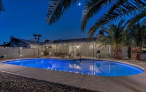 a swimming pool in front of a house with a palm tree at Premium Home With Free Private Heated Pool! in Tempe