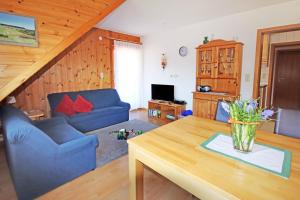 a living room with a blue couch and a table at Ferienhof Bühler in Schramberg