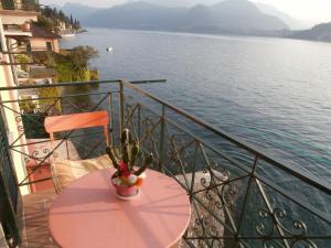 a table on a balcony with a view of the water at Casa sullo Sperone in Varenna