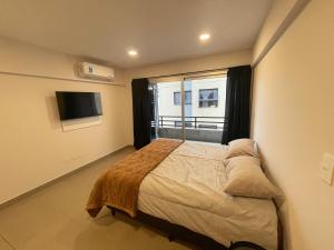 a bedroom with a bed and a large window at Otero Coliving - Studio Entero U7 in San Salvador de Jujuy