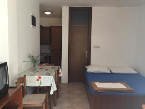 a room with a bed and a table and a television at Apartments Antonia in Malinska