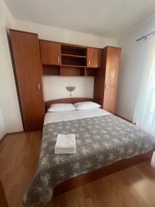 a bedroom with a large bed with wooden cabinets at Sunce Mobile Homes & apartments in Grebaštica +47 photos