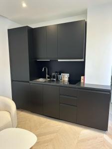 una cucina con armadi neri e lavandino di Luxury Apartment Champ de Mars Eiffel Tower a La Celle-sous-Gouzon