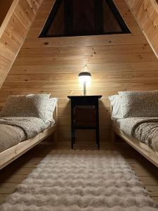 a bedroom with two beds and a table with a lamp at White Forest Durmitor 2 in Žabljak