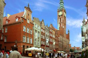 a clock tower in a city with a crowd of people at Długa Apartments Old Town in Gdańsk