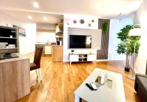 ein Wohnzimmer mit einer Couch, einem Fernseher und einem Tisch in der Unterkunft Apartamento Centro Torremolinos in Torremolinos