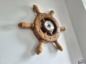 a wooden wall clock on a white wall at Flotnar Hús - Newbuild B&B in Keiss +51 photos
